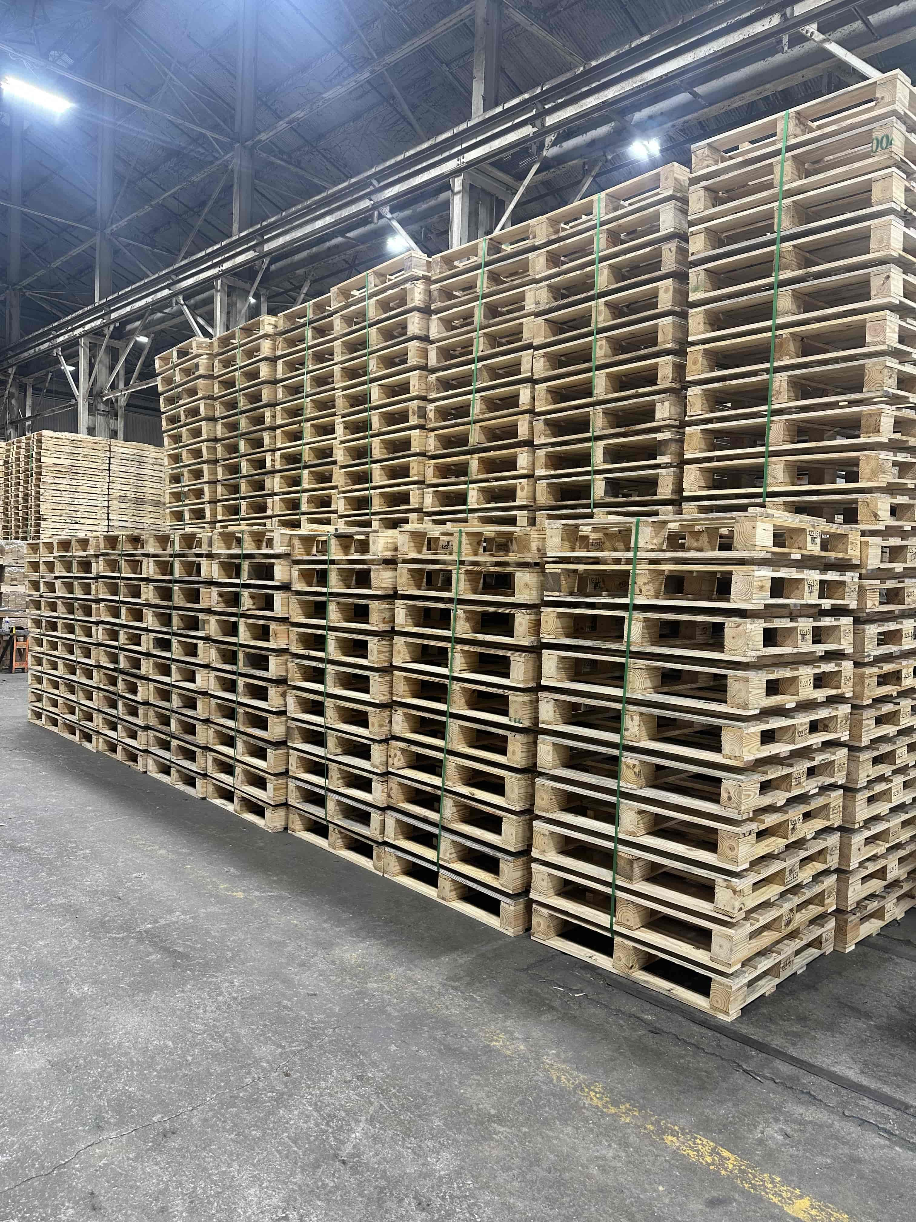 Forklift moving stack of wood pallets